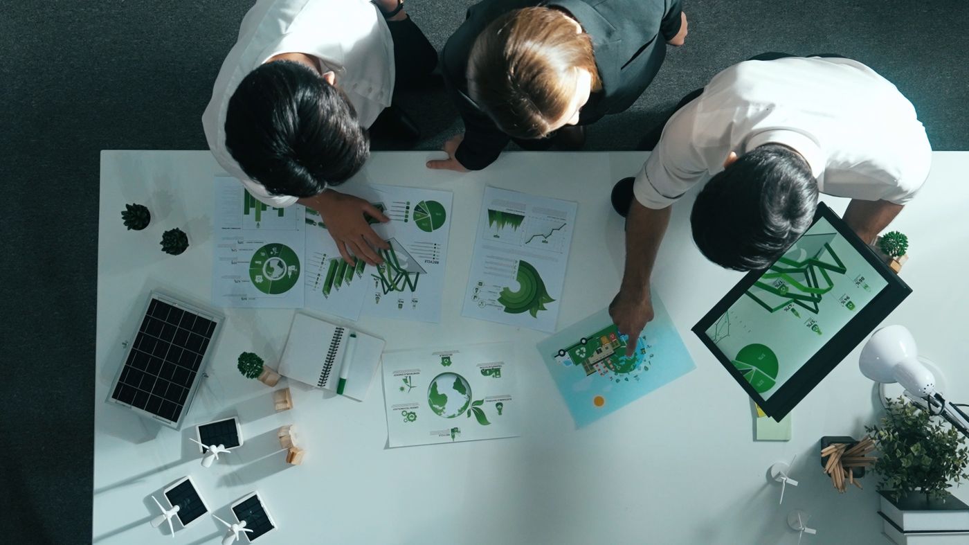 A team reviewing green energy charts at a table